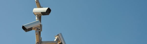 企业多分支网络运维场景，IT工程师在监控大屏前查看 netc 拓扑图，多个城市节点实时连线，专业蓝绿色调